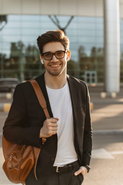 happy-businessman-in-eyeglasses-looks-into-camera-and-smiles-sincerely-brunette-guy-in-black-jacke