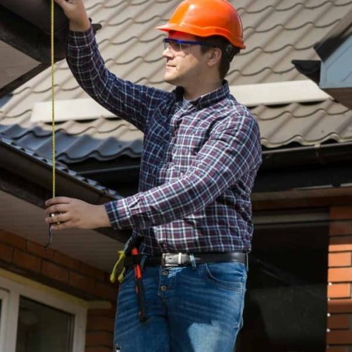 professional-worker-measuring-height-of-roof-with-tape