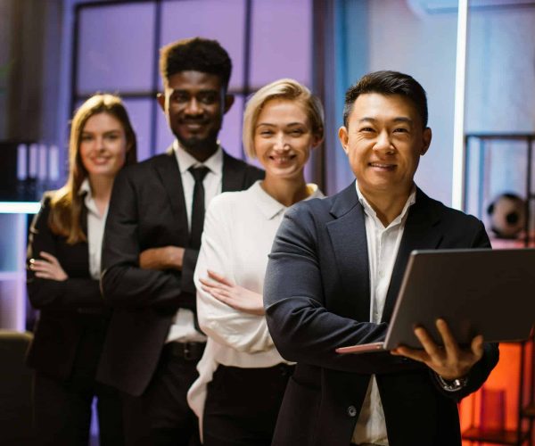 multiethnic-happy-company-workers-standing-in-a-row-in-creative-office-posing-on-camera